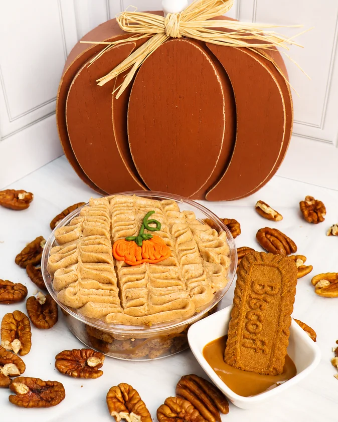 Postre con forma de calabaza rodeado de galletas y nueces.