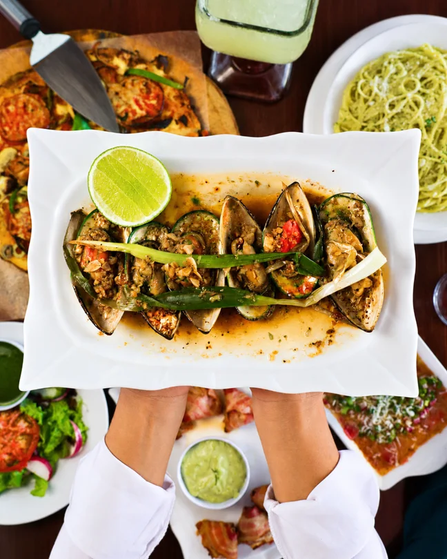 Mesa vista desde arriba con tacos, limón y varios platos.